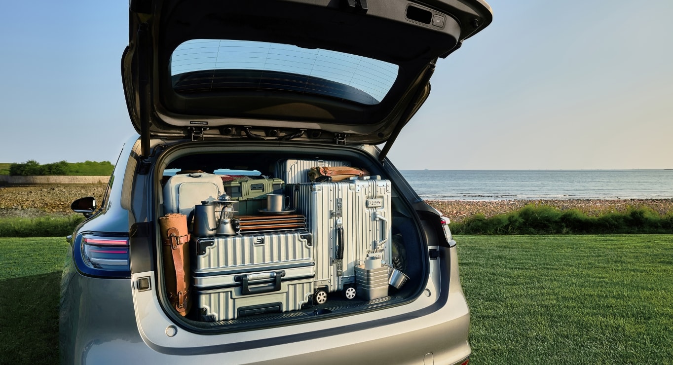 A child sitting in the hidden compartment of the SAIC H5's rear trunk, with toys stored beside